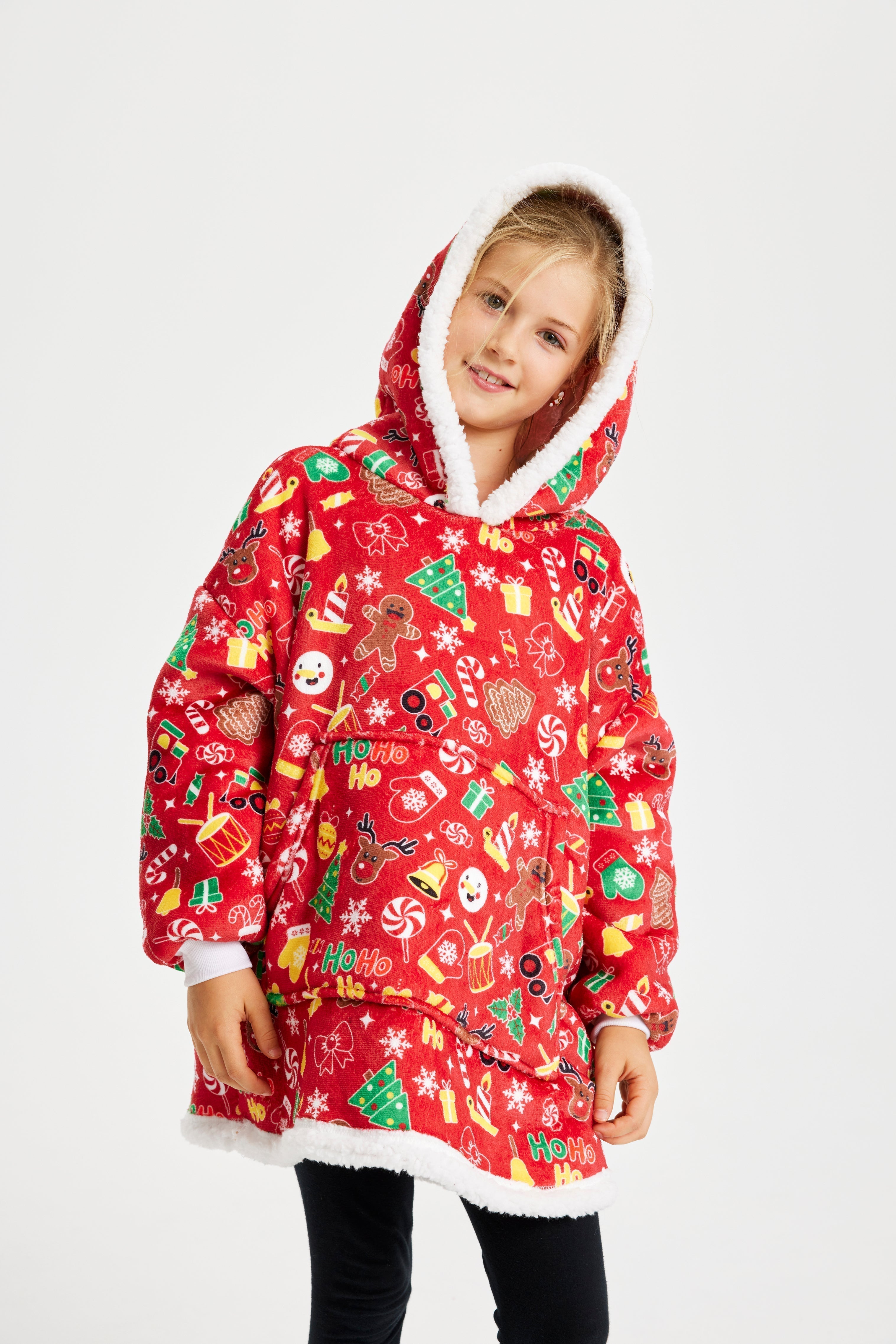 Un enfant pose en portant des sweats à capuche à motifs de Noël.